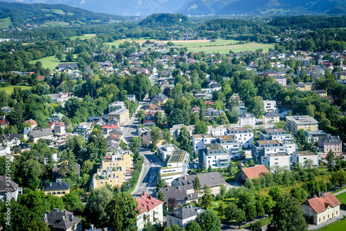 Houses surrounded with trees in the Salzach river valley below the mountains  © Tasawer