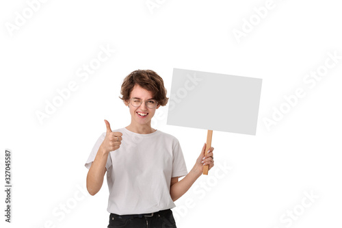 Smiling young woman holding empty signboard with copy space and showing thumb up photo