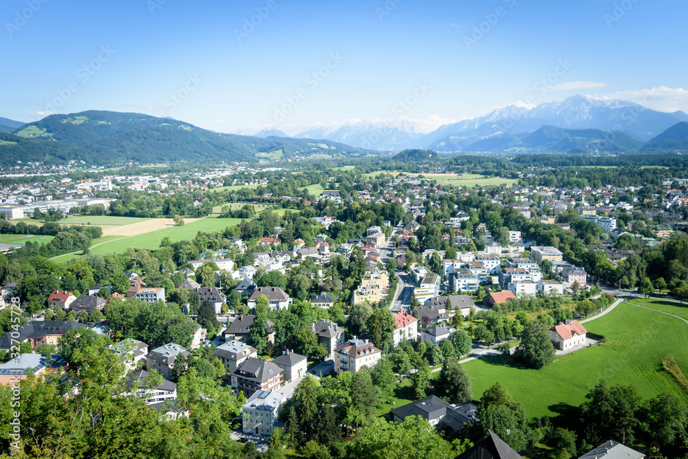 Houses surrounded with trees in the Salzach river valley below the mountains 