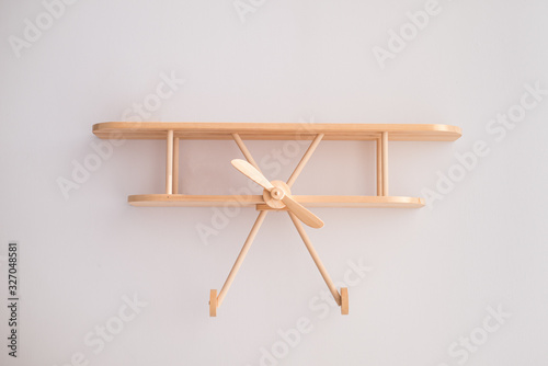 Shelf in the children's room. Wooden shelf in the form of an airplane