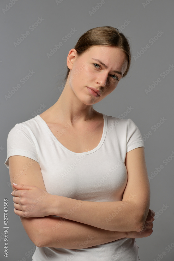 portrait of a young beautiful girl in a white t-shirt on a gray background portrait of a young beautiful girl in a white t-shirt on a gray background
