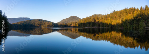 Beautiful and Vibrant panoramic view of a lake surounded by Canadian Mountain Landscape during sunset. Taken in White Pine Beach  Port Moody  Vancouver  British Columbia  Canada. Panorama