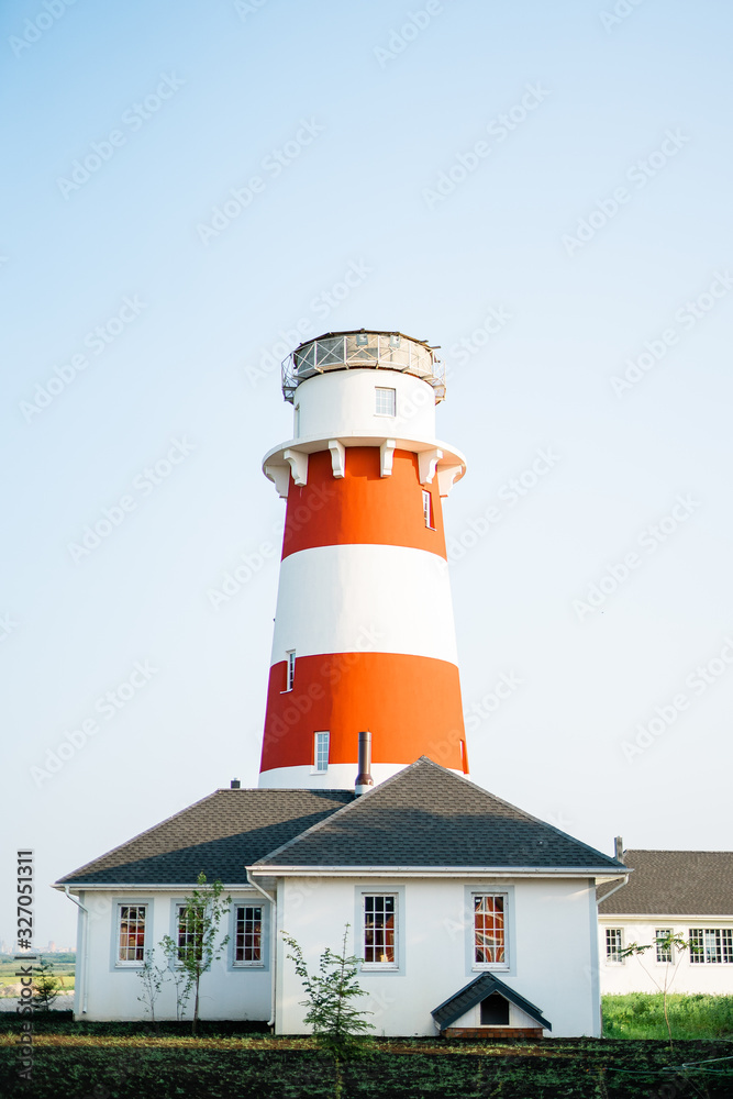 Lighthouse with house on the blue skies background