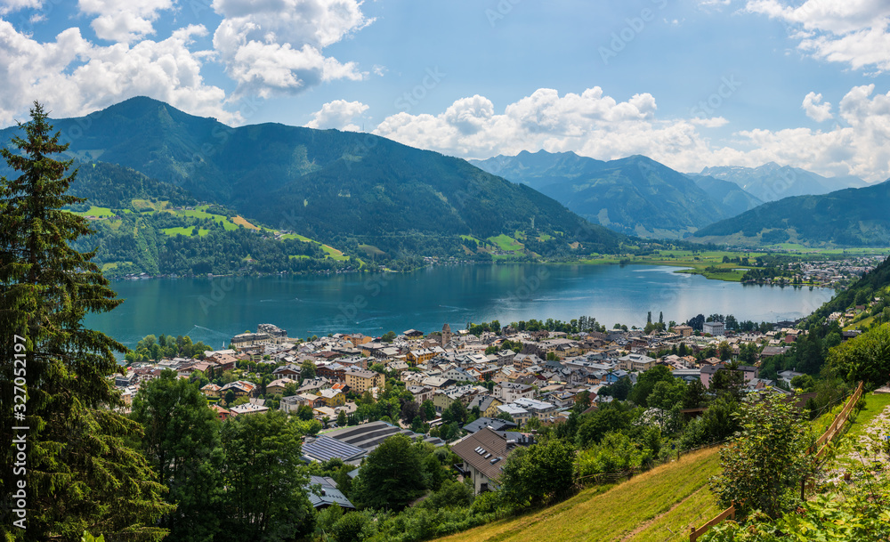 Fototapeta premium Panorama of the city of Zell am See with Zeller Lake in summer. Nature panoramic view of mountain, meadows and Tirol Alps in Salzburger Land, Austria.
