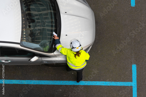 agente de aparcamiento poniendo una multa de estacionamiento