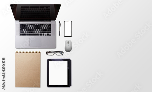 Office desk table with laptop, smart phone, cup of coffee and supplies, isolated on white background. Top view with copy space, flat lay.