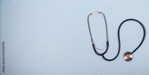 Medical stethoscope or phonendoscope  isolated on light blue background. Close-up of a stethoscope. flat lay. your text here