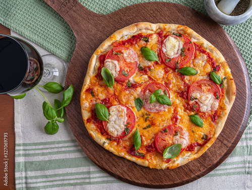 Pizza margherita with bazil on wooden board photo