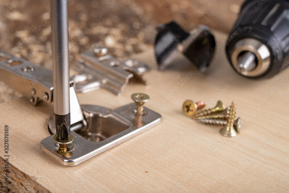 Installation of furniture hinges in chipboard. Small carpentry work in the workshop. Installation of furniture hinges in chipboard. Small carpentry work in the workshop.