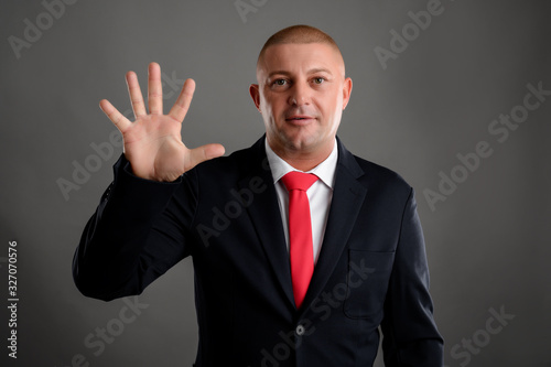 Businessman showing number five