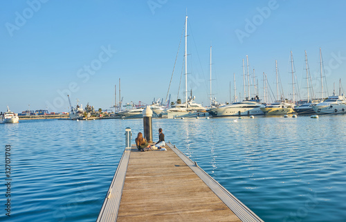 Teens taking pictures on the dock of the port of Valencia. © Nedrofly