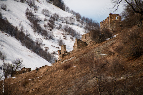 Landscape with ancient ruins in snowy mountains photo