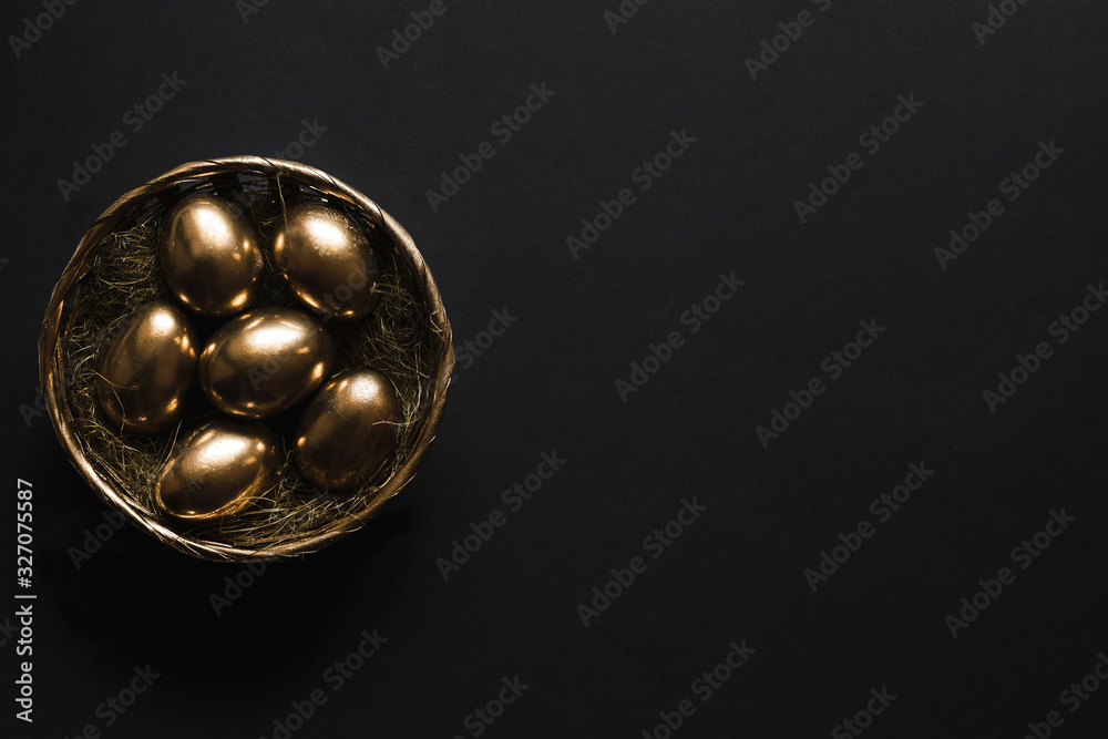  Golden eggs in nest on dark black background.A background for celebrating Easter Top view and copy space  Flatlay. Luxury  background and Minimal black trend 2020.