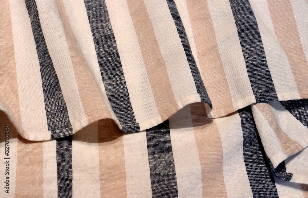Beige and gray striped linen. Scandinavian style. The material is folded casually on a horizontal surface. Fabric sample. Interior design option for curtains Beige and gray striped linen. Scandinavian style. The material is folded casually on a horizontal surface. Fabric sample. Interior design option for curtains