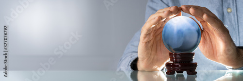 Midsection Of Businessman Covering Crystal Ball photo