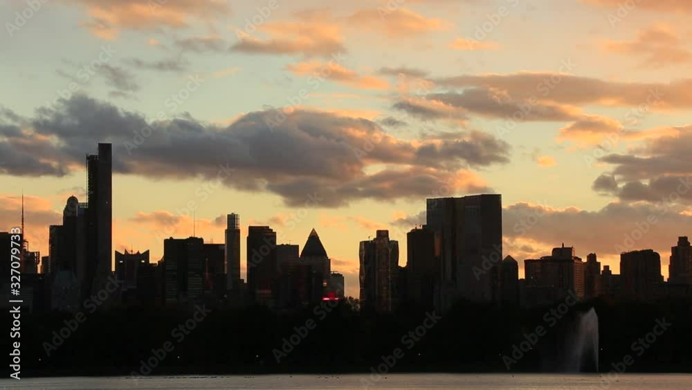 Sky, Clouds and Central Park Reservoir glow and illuminate by sunset. Central Park West Residences become silhouettes. Image was captured from Central park. Sky, Clouds and Central Park Reservoir glow and illuminate by sunset. Central Park West Residences become silhouettes. Image was captured from Central park.