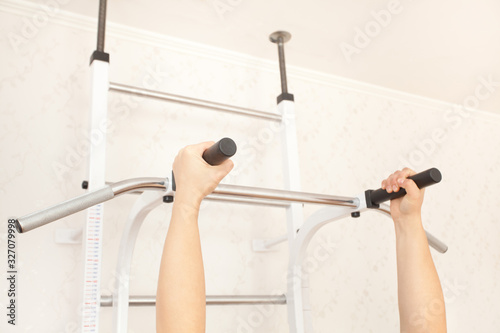 Man pulls himself up. Gymnastic wall staircase for playing sports at home