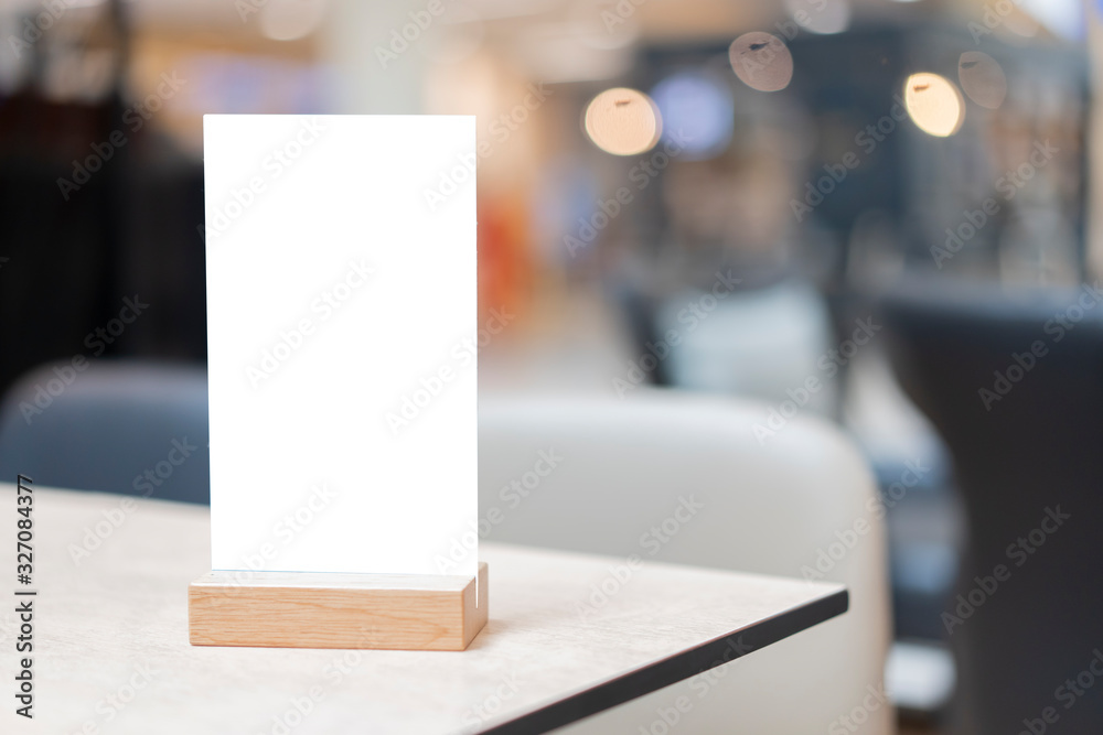 Mock up Label the blank menu frame in Bar restaurant ,Stand for booklets with white sheets paper acrylic tent card on wooden table cafeteria blurred background can inserting the text of the customer. Mock up Label the blank menu frame in Bar restaurant ,Stand for booklets with white sheets paper acrylic tent card on wooden table cafeteria blurred background can inserting the text of the customer.