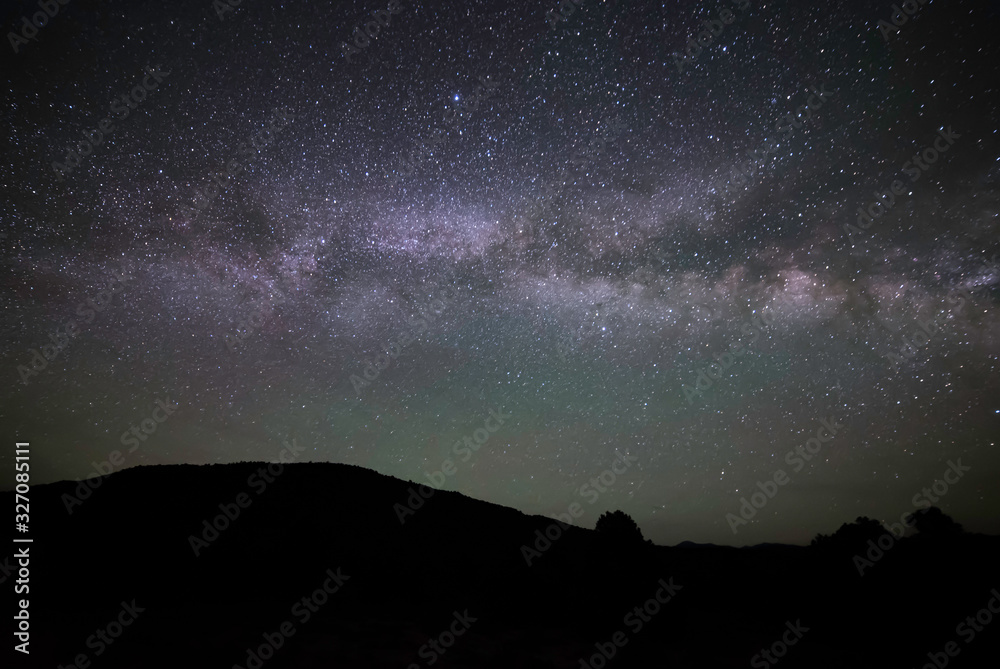 Horizontal Milky Way Galaxy going across the Night Sky seen from West Stone Cabin Valley with a silhouette of mountain hills from the Monitor Range in Nye County, Nevada, USA