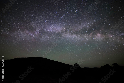 Horizontal Milky Way Galaxy going across the Night Sky seen from West Stone Cabin Valley with a silhouette of mountain hills from the Monitor Range in Nye County, Nevada, USA