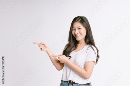 Beauty Asian woman smiles with a charming and shows something to you with healthy skin, teeth and hair isolated on white background, The lady in a summer t-shirt Short jeans. Copy space