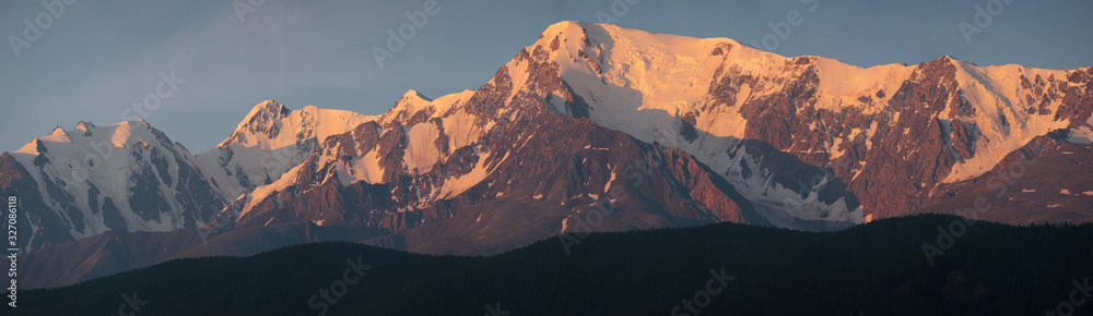 Panoramic mountain view, hiking in the mountains. Dawn light on the tops. Traveling in Russia, Altay.
