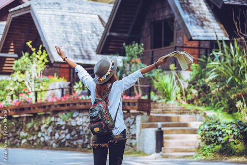 Freedom traveler woman standing with raised a book in hand arms and enjoying a beautiful nature. space for text.
