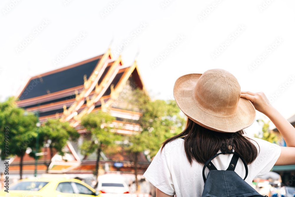 Back view of asian young woman traveller at temple Wat pho famous destination landmark.