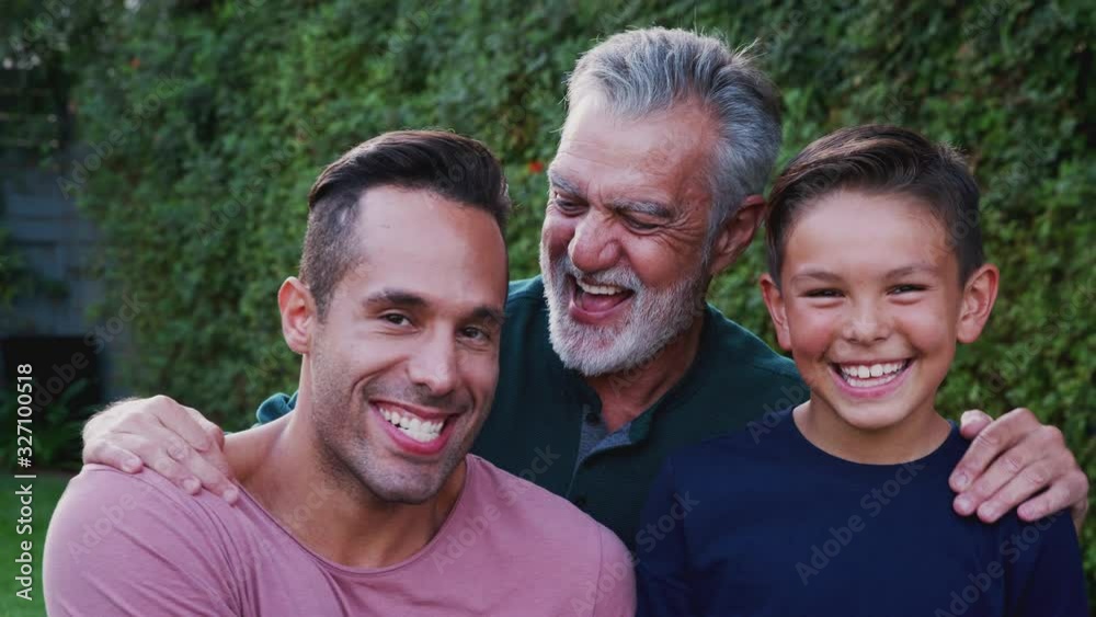 Portrait Of Multi-Generation Male Hispanic Family In Garden Smiling At Camera Portrait Of Multi-Generation Male Hispanic Family In Garden Smiling At Camera