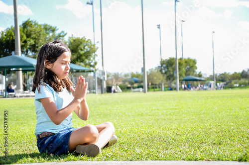 Foto young girl meditation arms up chant yoga sitting grass focus om santi sun shinin