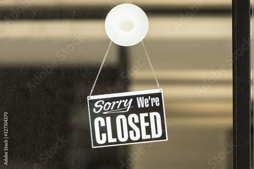 Fototapeta sorry we are closed sign hanging outside a restaurant, store, office or other