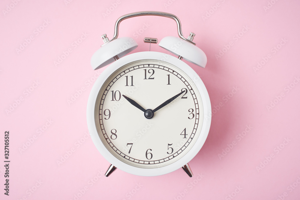 White retro alarm clock on the pink background with copy space. Time concept White retro alarm clock on the pink background with copy space. Time concept