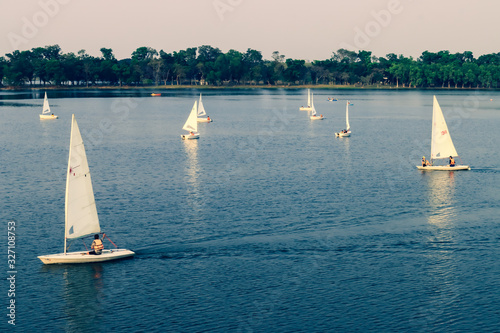 Aerial view on white sailboats leaving wake in the lake.