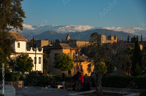 People observe Alhambra palace from Placeta Cristo de las Azuzenas viewpoint in Granada, Spain