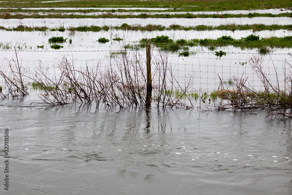 Flooded river after heavy storm rainfall flooding adjacent farmland Flooded river after heavy storm rainfall flooding adjacent farmland