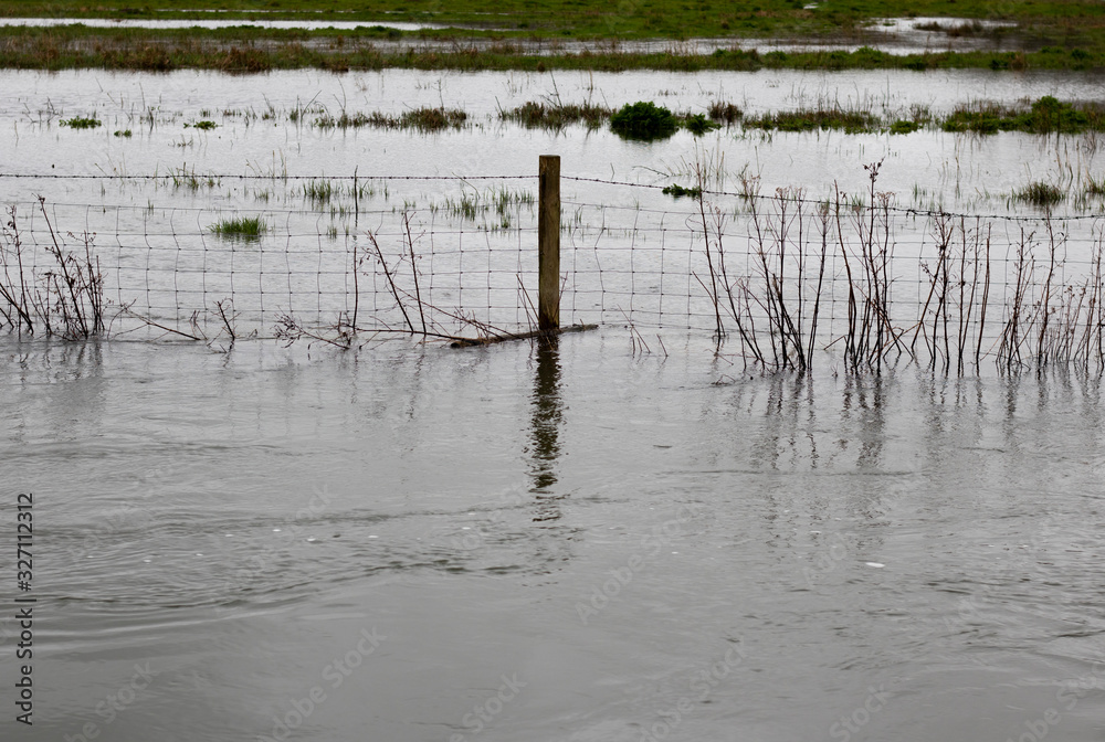 Flooded river after heavy storm rainfall flooding adjacent farmland