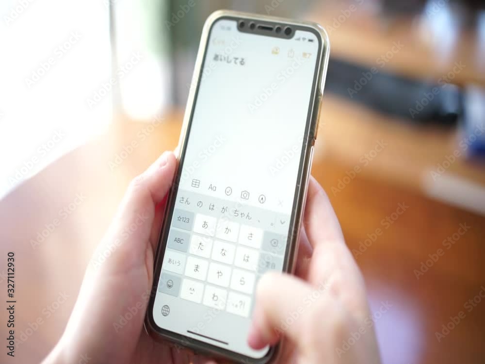 スマートフォンを使って「愛してる」とフリック入力する女性の手 スマートフォンを使って「愛してる」とフリック入力する女性の手