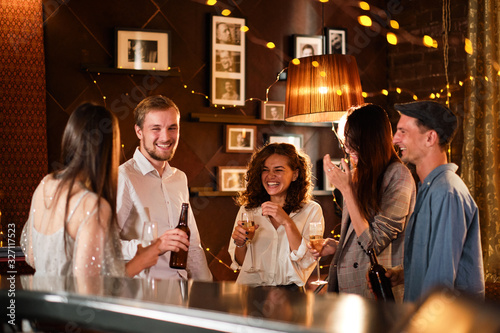 Happy group of friends at the bar having drinks.