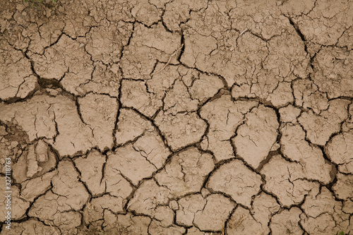 Close-up photograph of cracked earth underfoot. Natural Wallpaper, Texture, Pattern, Background.