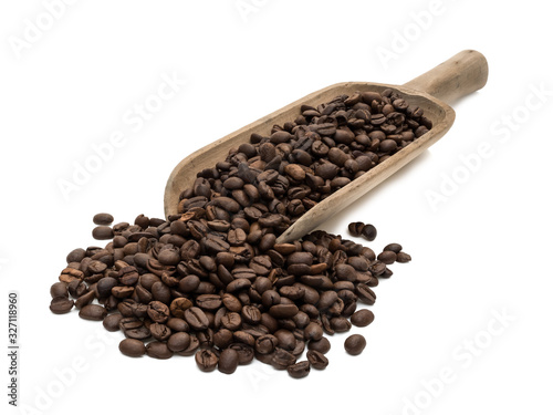 Roasted coffee beans on a large wood scoop seen obliquely from front isolated on white background