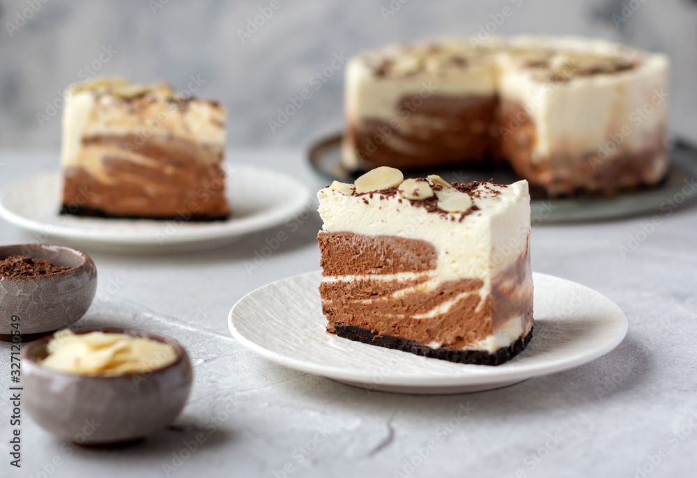 Two pieces of homemade raw chocolate cheesecake or mousse cake, decorate with almond flakes and chocolate morsels Two pieces of homemade raw chocolate cheesecake or mousse cake, decorate with almond flakes and chocolate morsels