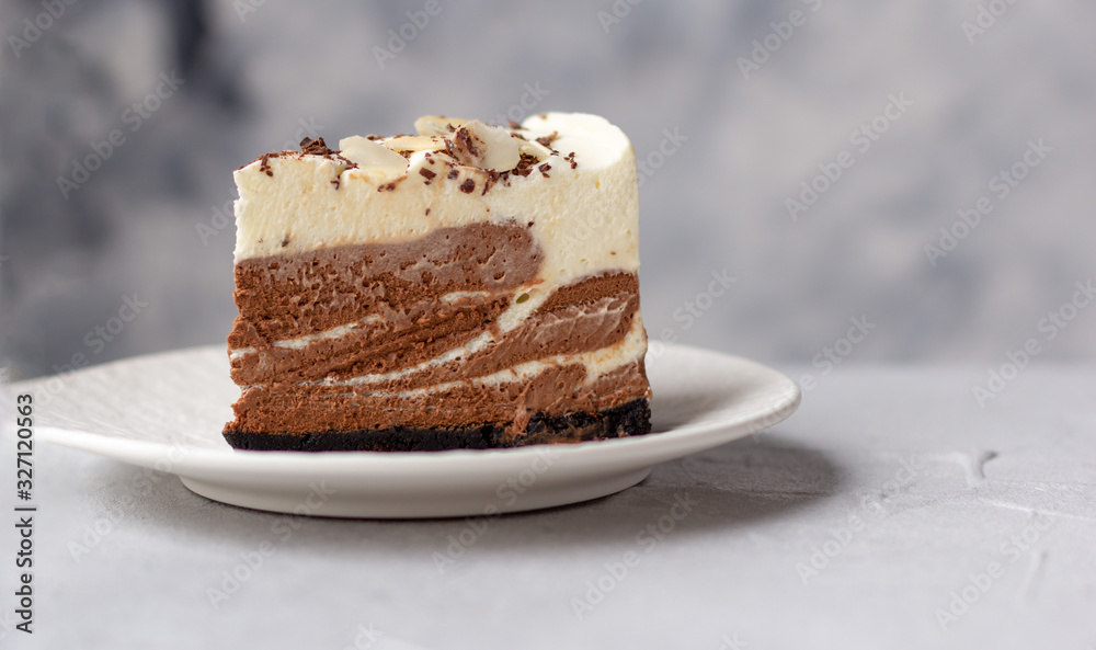 A piece of homemade raw chocolate cheesecake or mousse cake on white plate A piece of homemade raw chocolate cheesecake or mousse cake on white plate