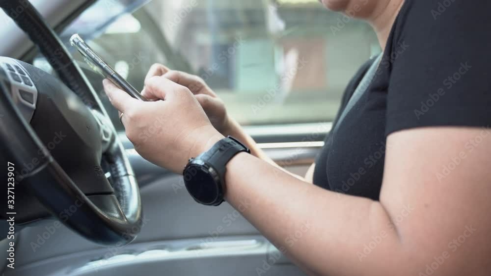 Female reading a text message on cellphone while traffic car Female reading a text message on cellphone while traffic car