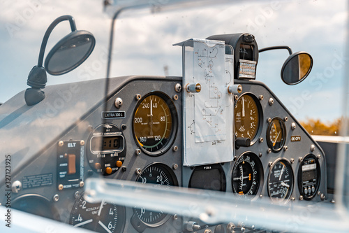 Cockpit of an Extra 300 L aerobatic monoplane with pilots for stunt figues notes pinned on the instruments.