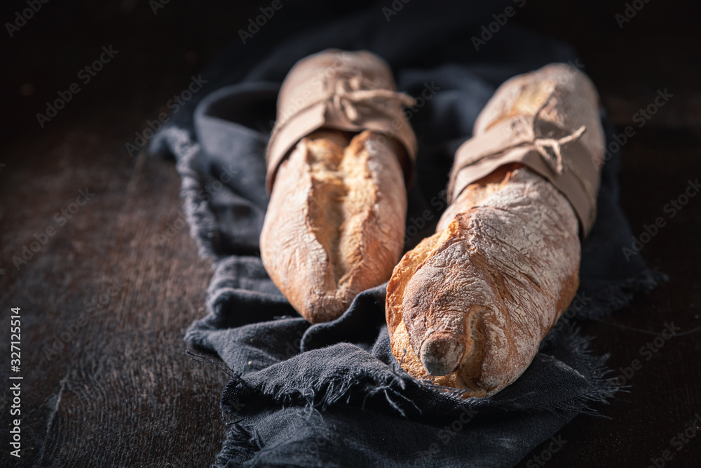 Delicious golden baguettes on old wooden table