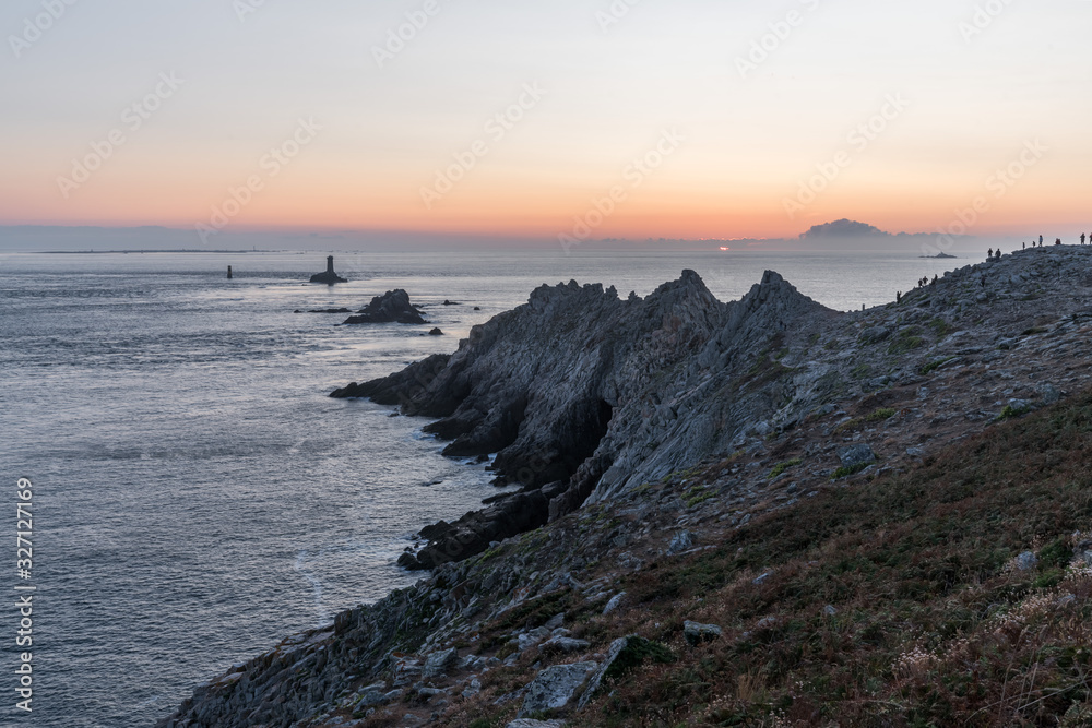 Sunset landscapes at the Raz Point (Pointe du Raz) with cliffs into the sea, Brittany, France