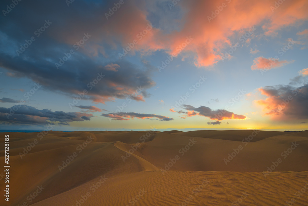 After Sunset in the desert, Beautiful blue sky and fluffy pink blue clouds. Fine, golden sand of the dunes of the desert in Maspalomas, Gran Canaria at Canary islands, Spain