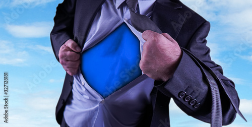 Canvas-taulu Superhero, young businessman tearing his shirt off isolated on dark background w