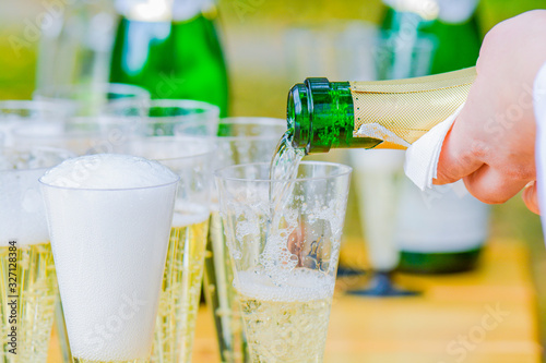 Bartender pouring champagne into glasses. Wedding reception photo