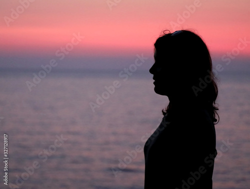 black profile of young woman with long hair and the sea at sunse © ChiccoDodiFC